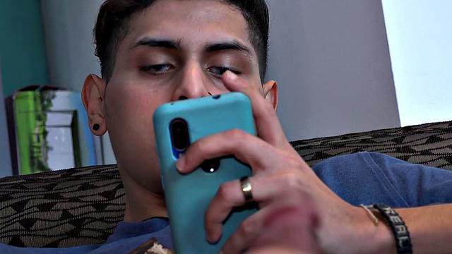 Stretched out on a sofa and watching porn on his phone, Tommy starts working up a stiff one. Once hard, the Latino starts beating off, with eyes glued to the phone.