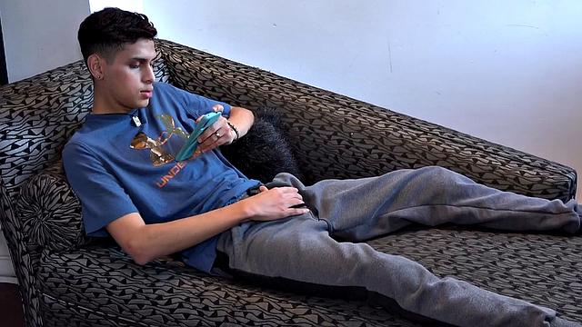 Stretched out on a sofa and watching porn on his phone, Tommy starts working up a stiff one. Once hard, the Latino starts beating off, with eyes glued to the phone.